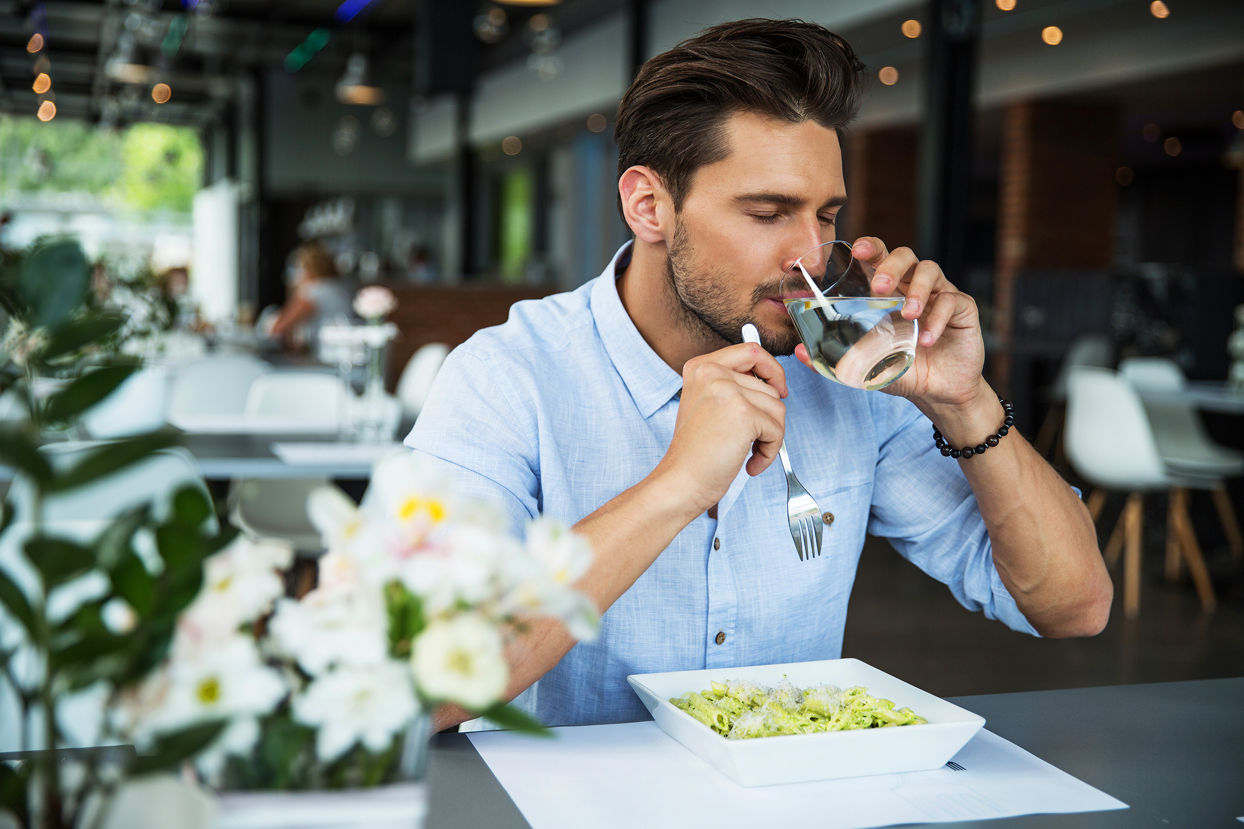 Mann trinkt Wasser im Restaurant
